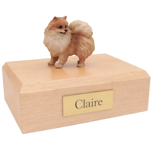 Memorial cremation urn with standing brown and white Pomeranian dog figurine, maple finish