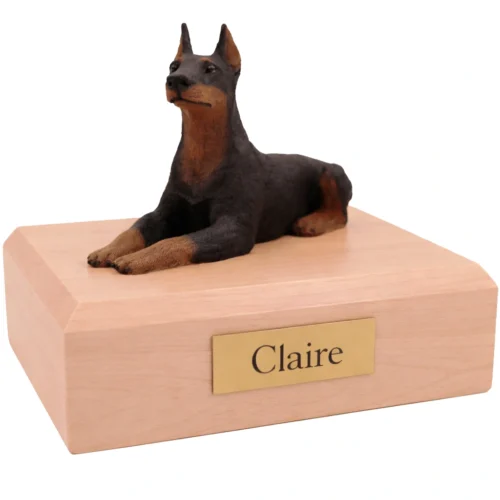 Memorial cremation urn with laying ears up Doberman Pinscher dog figurine, maple finish