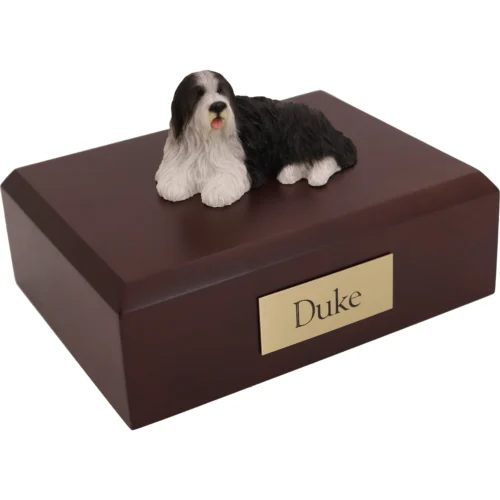 Memorial cremation walnut finish urn with laying black and white Bearded Collie dog figurine