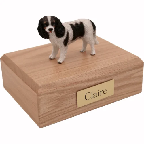 Memorial cremation urn with standing black and white King Charles Spaniel dog figurine, oak finish