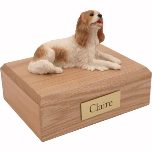 Memorial cremation urn with laying brown and white King Charles Spaniel dog figurine, oak finish