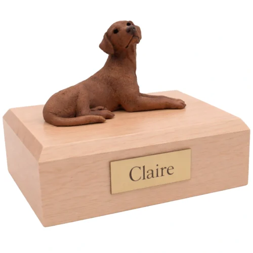 Memorial cremation urn with laying chocolate Labrador Retriever dog figurine, maple finish