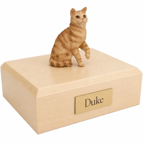 Memorial cremation urn with sitting red shorthaired tabby cat figurine, maple finish