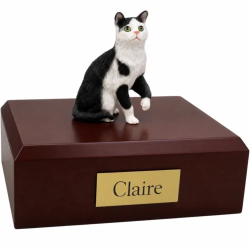 Memorial cremation urn with sitting black and white shorthaired tuxedo cat figurine, walnut finish