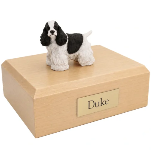 Memorial cremation urn with standing black and white Cocker Spaniel dog figurine, maple finish