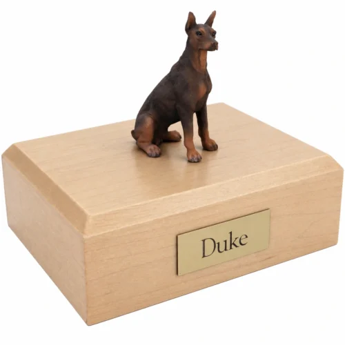 Memorial cremation urn with sitting red Doberman Pinscher dog figurine, maple finish